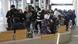 A crowd of people wait inside at a bus interchange in Christchurch, New Zealand