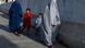 Afghan burqa-clad women walk down a road in Kandahar on August 28, 2024